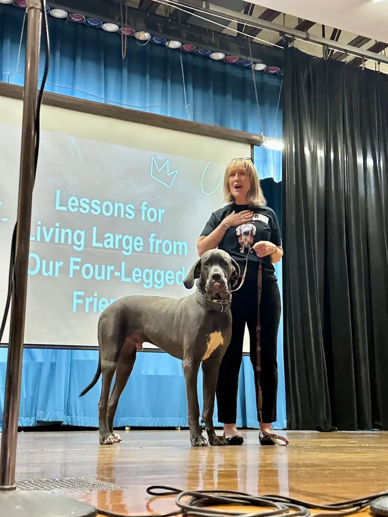 Barb Stone on stage with her Great Dane dog named Zeus